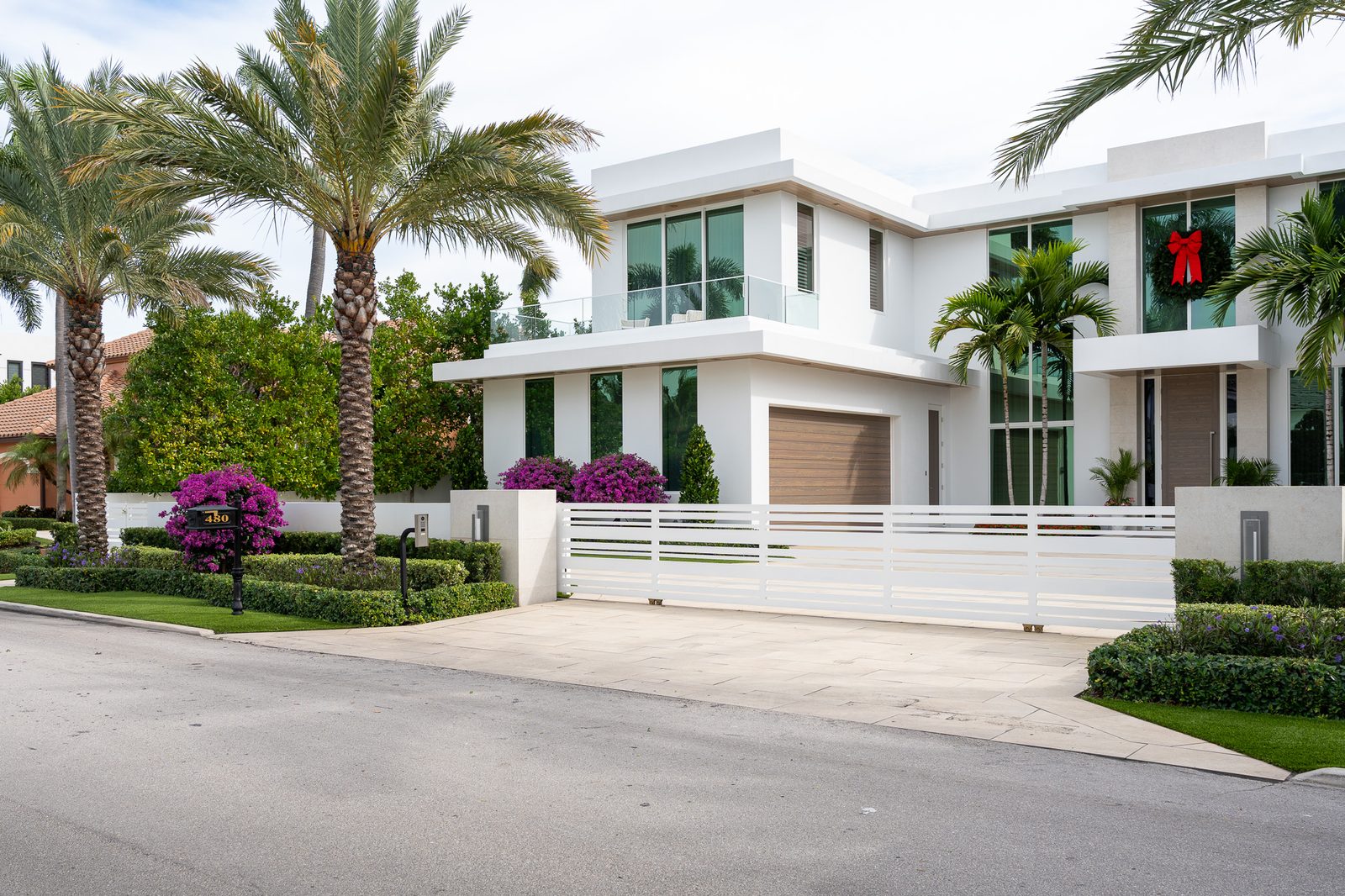 Palm-lined driveway and manicured hedges at a South Florida estate